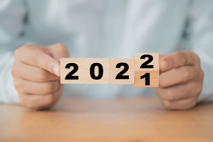 Businessman flipping wooden cube block to change 2021 year to 20